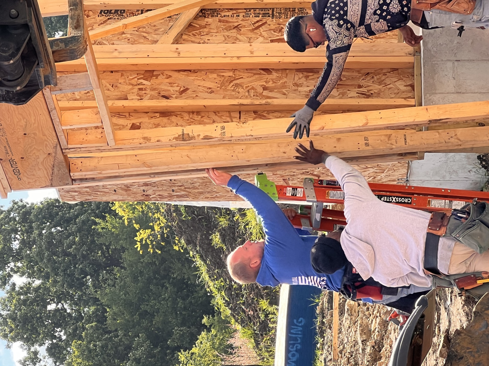 Crew member guiding a beam into place — T.R. Grant Construction