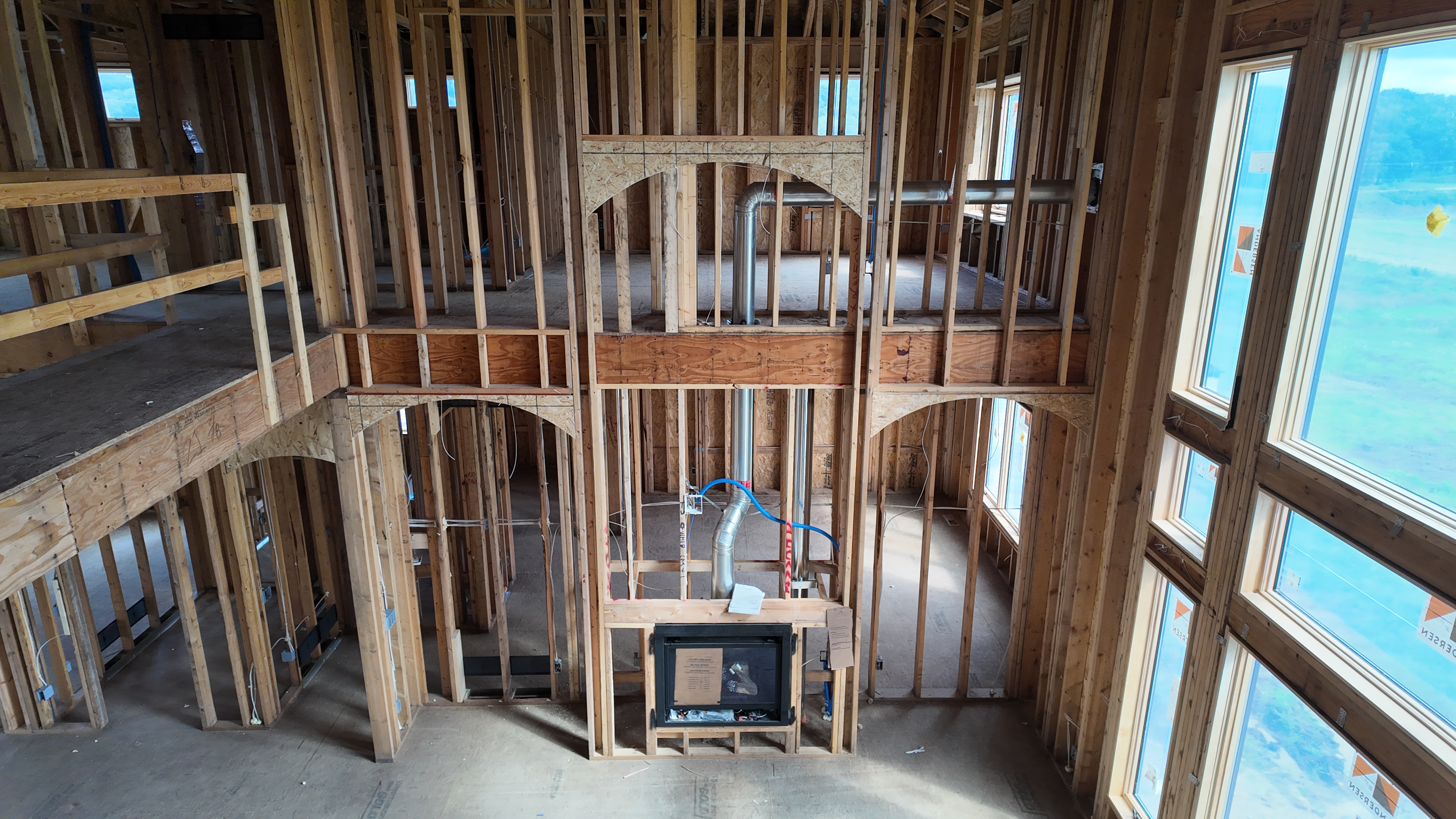 Two-story great room framing with fireplace and arched windows