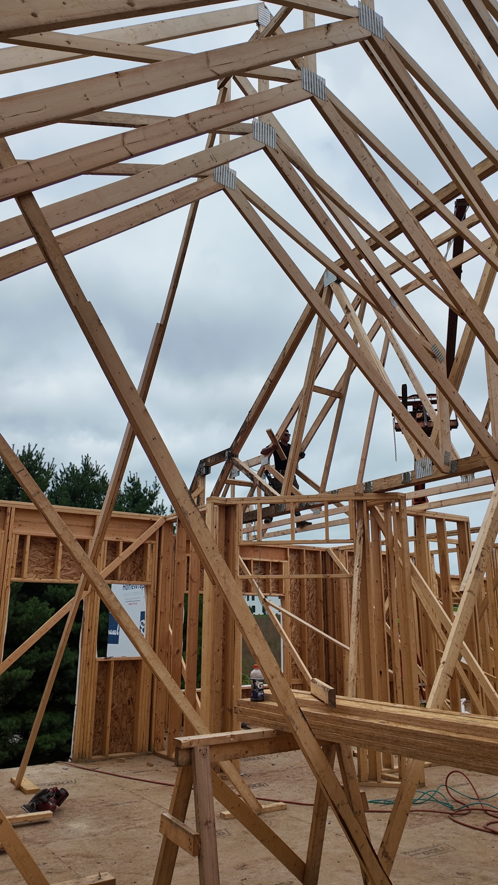 Crew setting roof trusses on a luxury custom home
