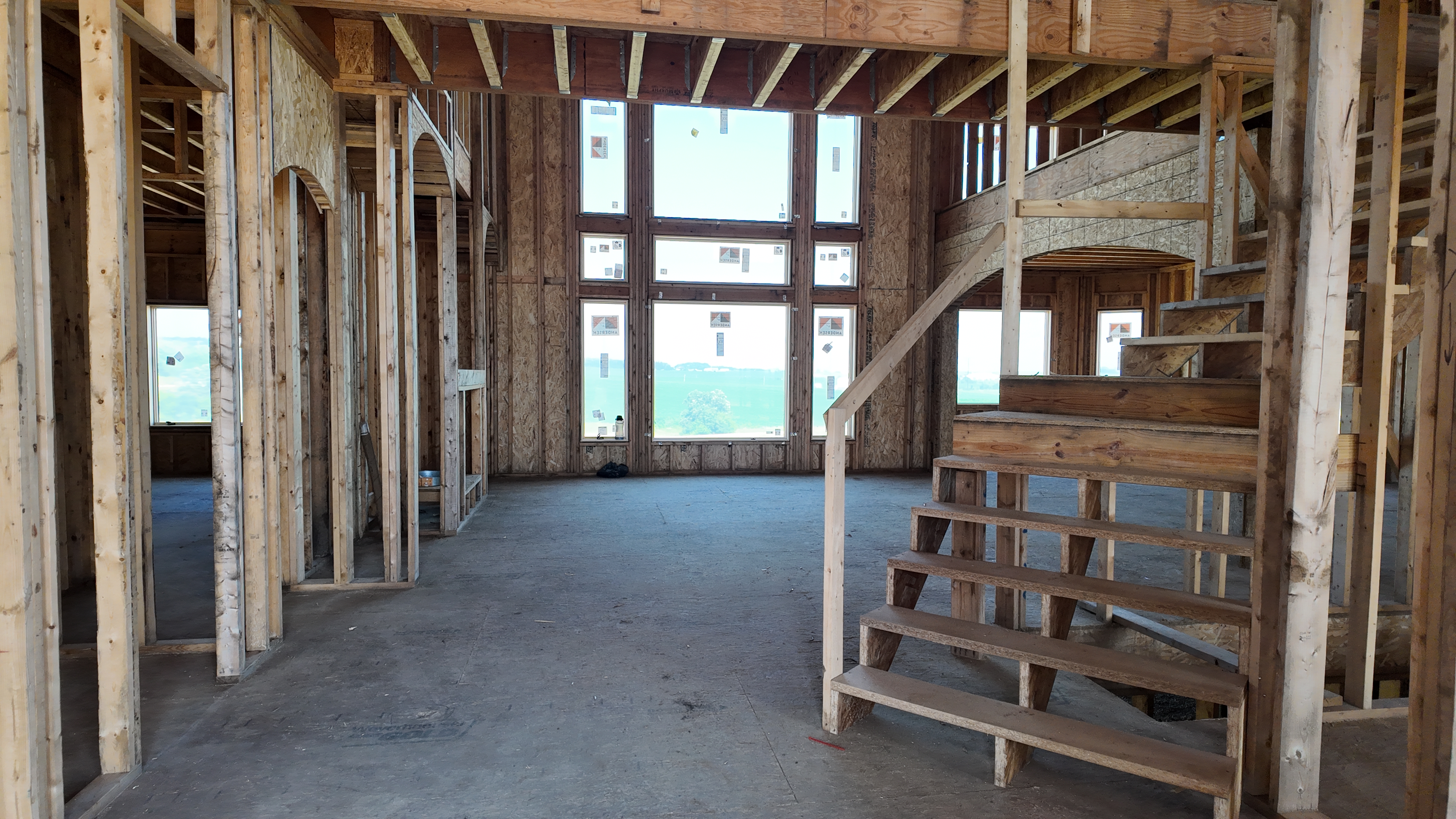 Interior luxury custom home framing with two-story great room and staircase